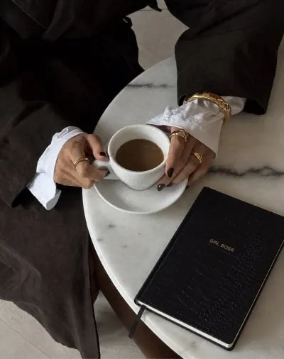 Kopje koffie en een notitieboek op een marmeren tafel
